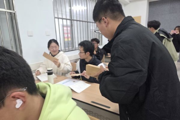 图一 学习部志愿者为同学们发放信封.jpg