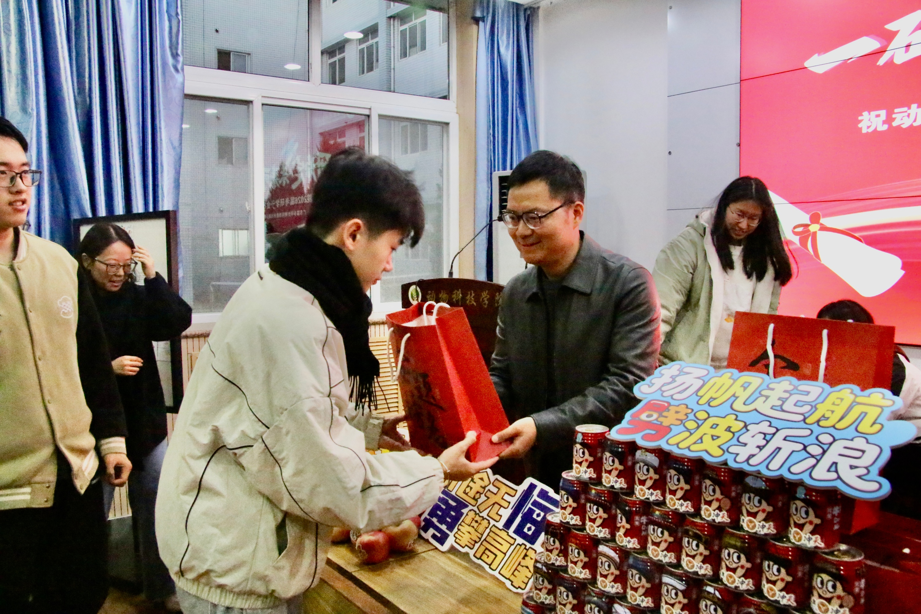 图三 丁老师为2026届考研学生发放慰问品.jpg